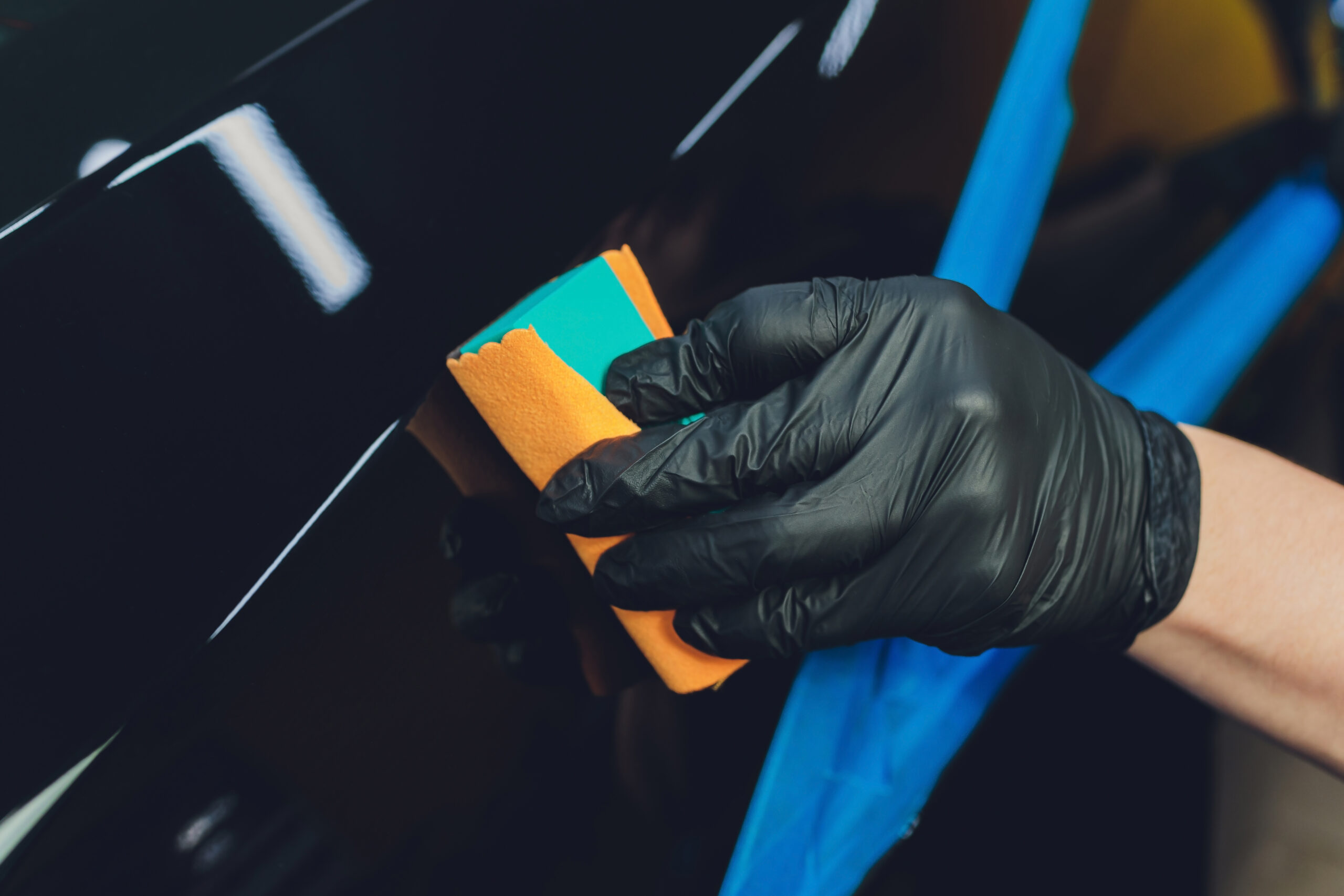 Car detailing - Man applies nano protective coating to the car. Selective focus. Car detailing - Man applies nano protective coating to the car. Selective focus
