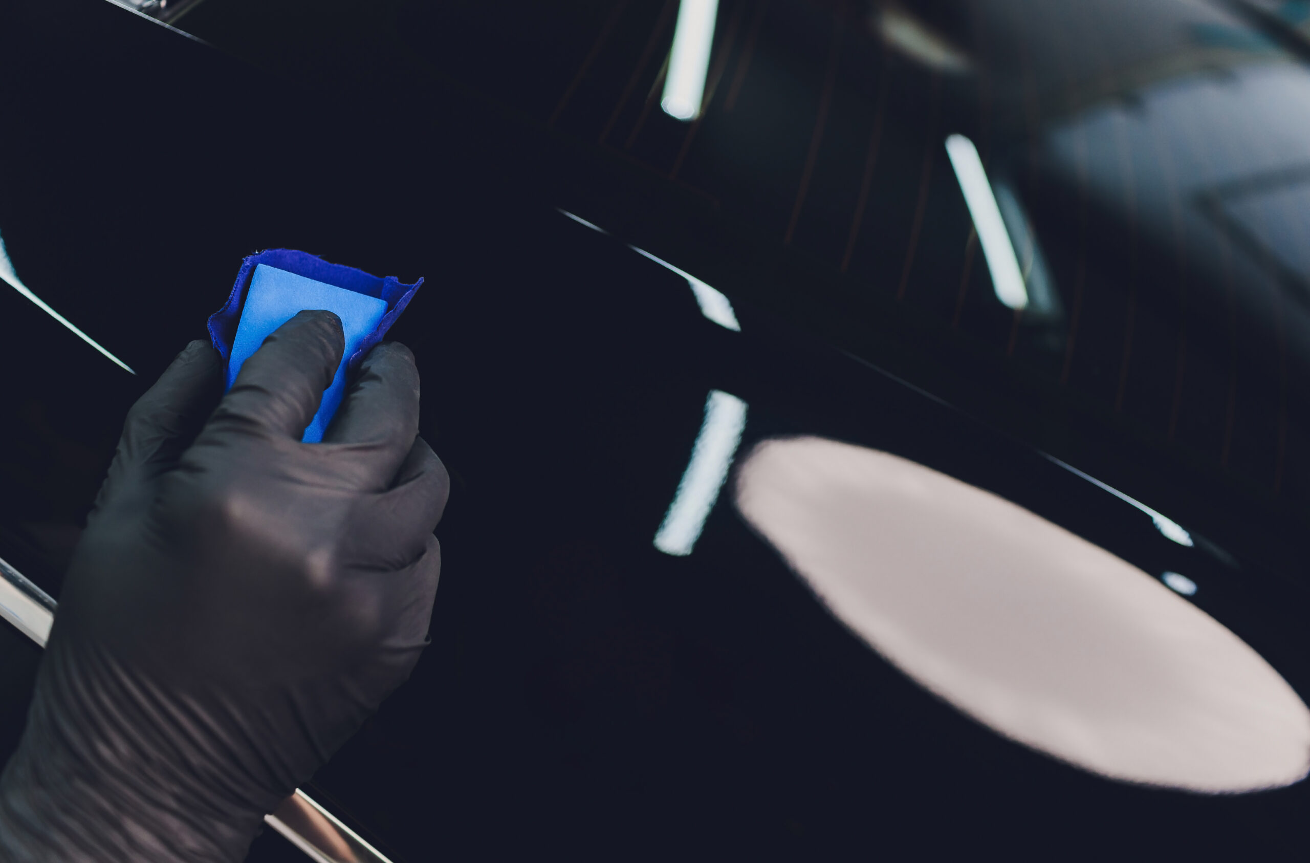 Car detailing - Man applies nano protective coating to the car. Selective focus. Car detailing - Man applies nano protective coating to the car. Selective focus